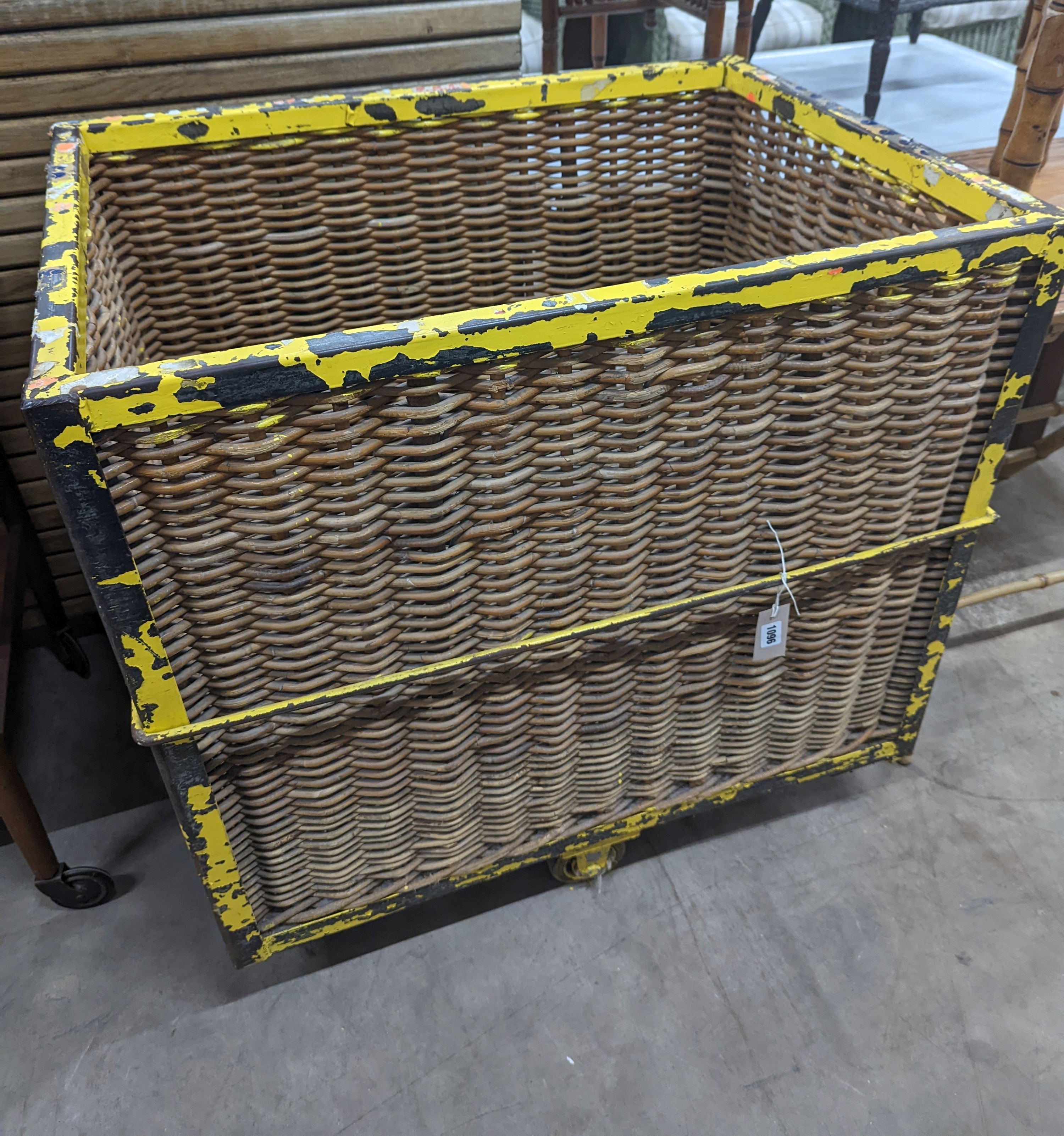 A vintage wicker and iron laundry basket on wheels, width 85cm, depth 61cm, height 87cm